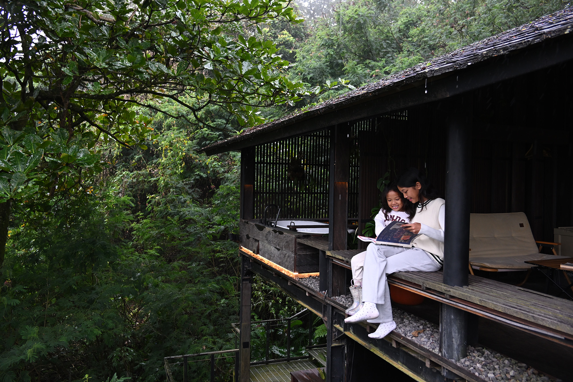 Two people reading a book in a forest