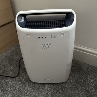 The white De’Longhi Tasciugo AriaDry Multi Dehumidifier being reviewed in a carpeted home