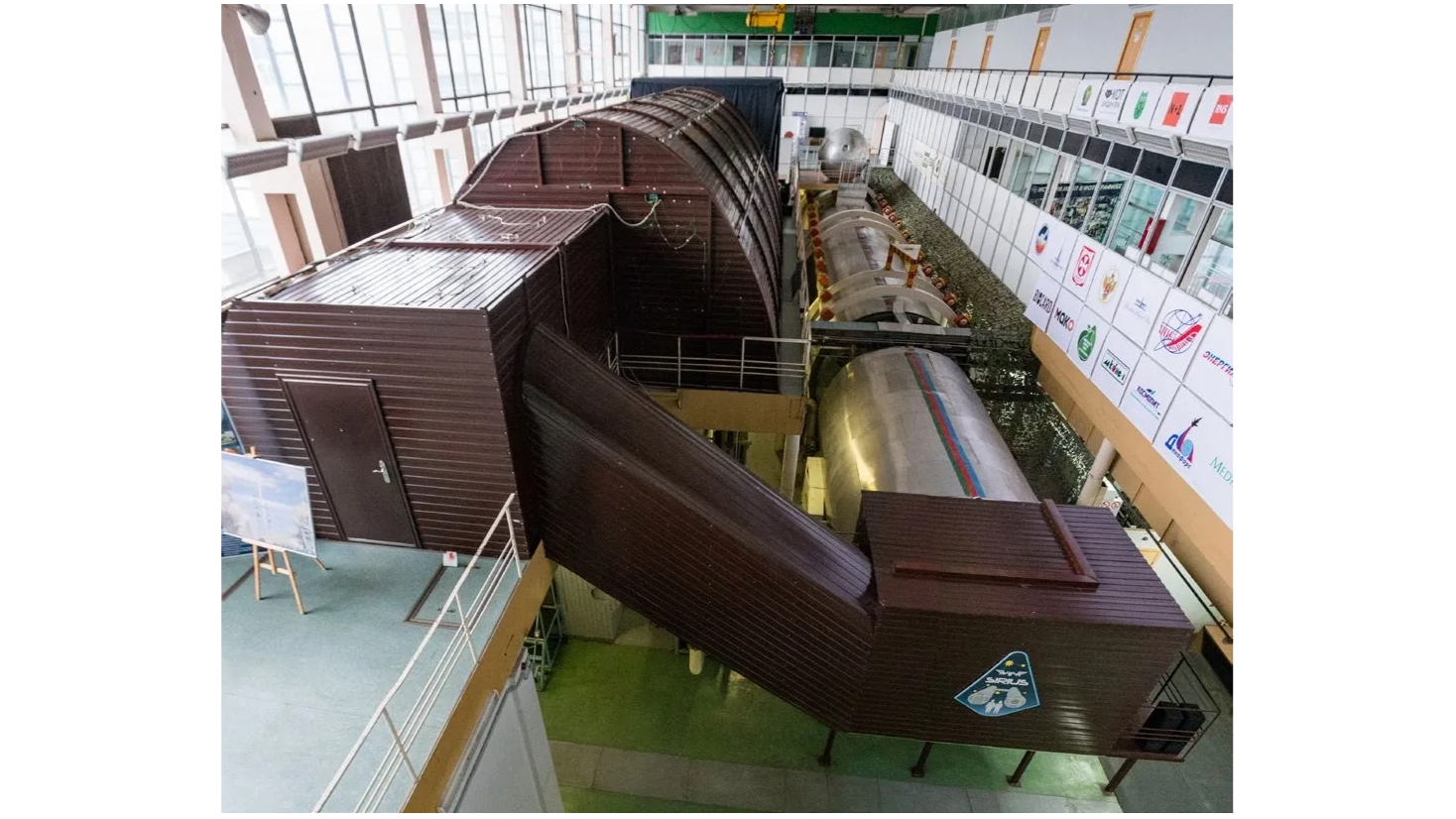 overhead view of several brown habitat buildings inside a warehouse-like structure