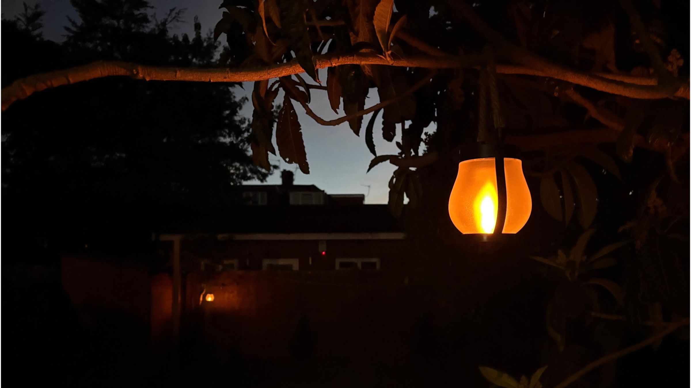 Adiwo Solar Flame Hemp Rope Lantern in garden after dark