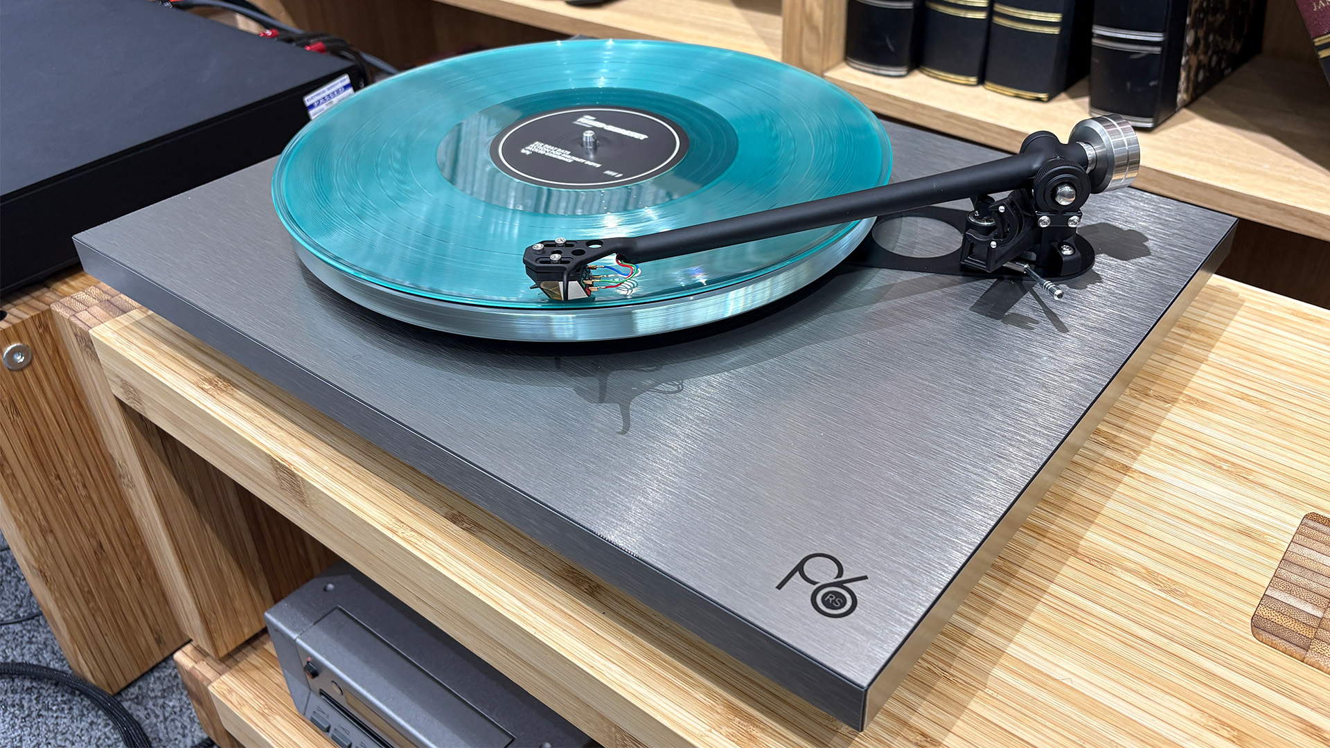 Rega Planar 6 RS Edition turntable on wooden hi-fi rack playing blue vinyl record