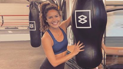 Lucy Gornall smiles next to a boxing bag having boxed every day for two weeks