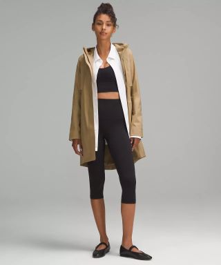 Lululemon model wearing beige rain jacket and black leggings