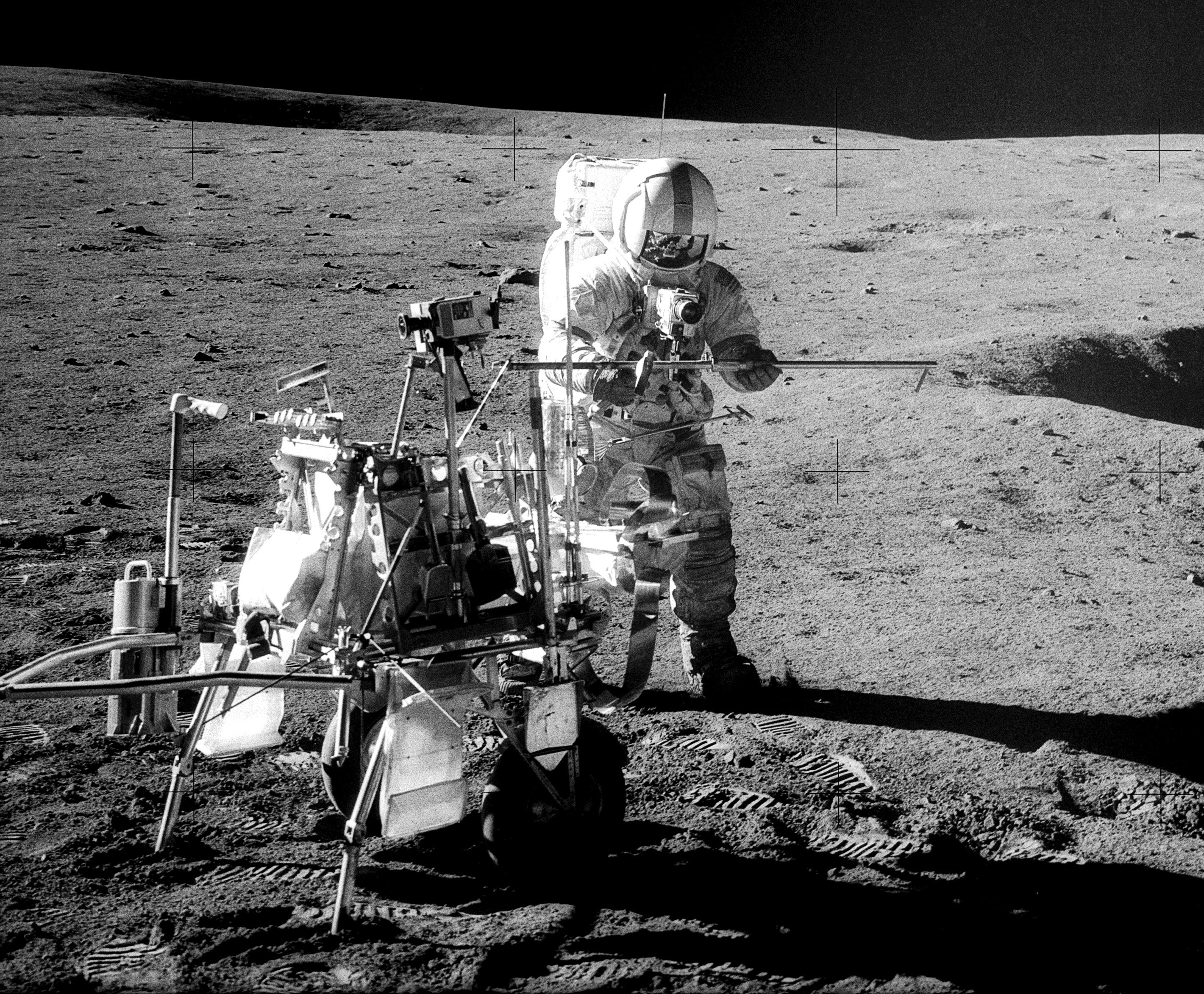 Apollo 14 moonwalker Alan Shepard stands next to the portable workbench, or Modular Equipment Transporter (MET), in February 1971.