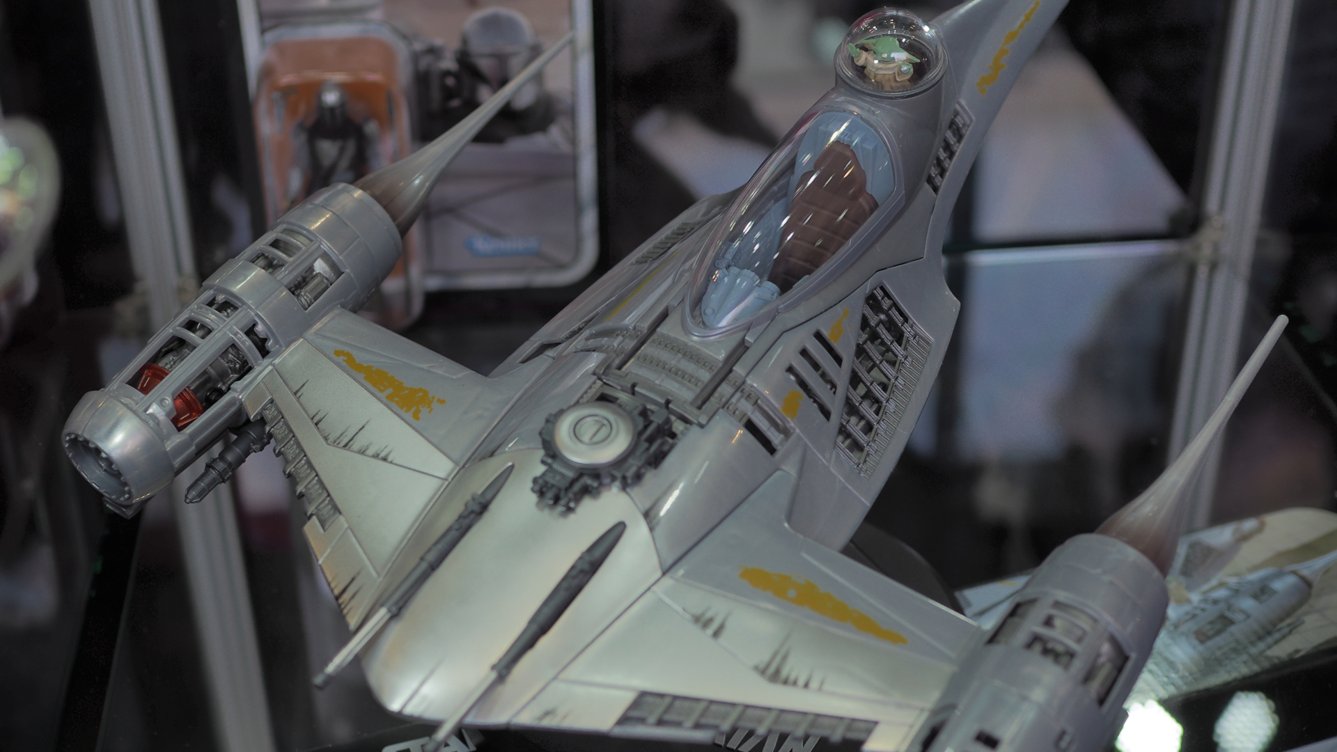An action figure of the N1 starfighter at a slight angle, with Grogu in the back pod