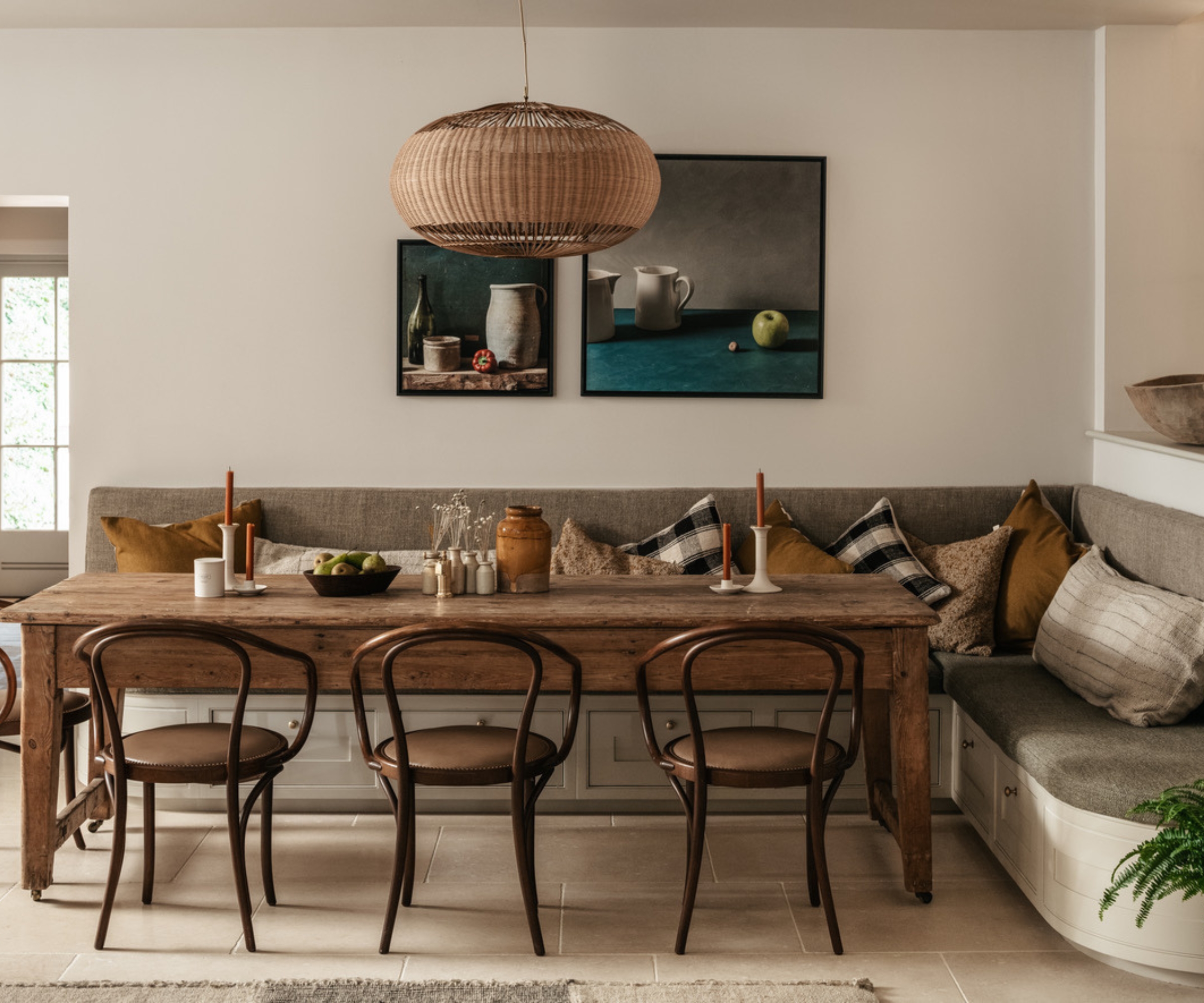 A dining nook with L-shaped banquette seating and a rectangular wooden table