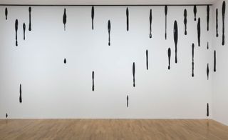 Drips of tar on white wall