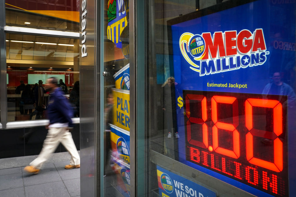 A man walks past a newsstand with advertisements for the Mega Millions lottery, October 23, 2018 in New York City.