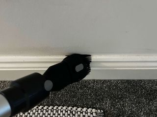 2 in 1 dusting brush being used moving horizontally across baseboards