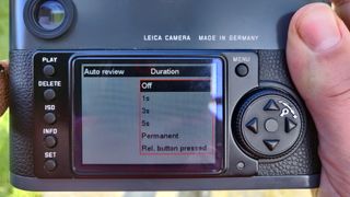 Leica M-E being held in the hand turning image preview off