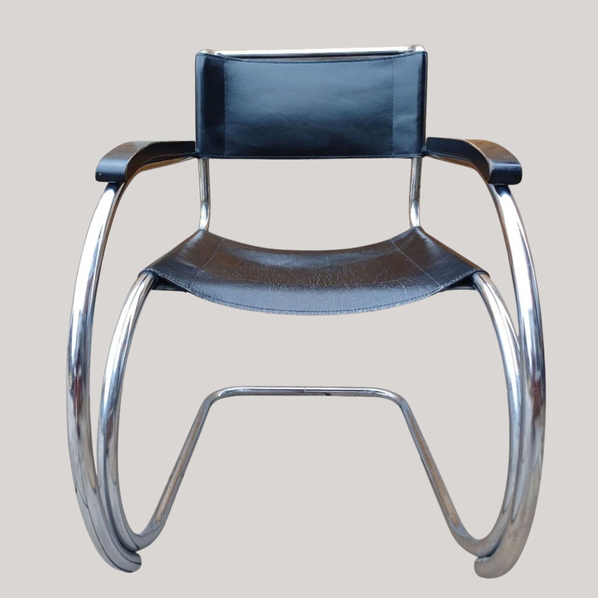 A black leather and tubular steel chair, shown against a pale gray background.