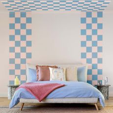 bedroom paint ideas, blue and pink pastel bedroom, blue and pink checks on the wall, blue bedding, boucle bed, rug, cushions 