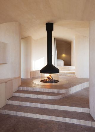 The cabin's four volumes branch out from a central fireplace