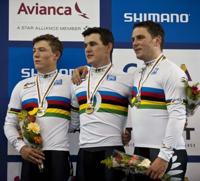 New Zealand's Ethan Mitchell (L), Sam Webster (C) and Edward Dawkins (R) sing the New Zealand national anthem following the gold medal victory in the Men's Team Sprint