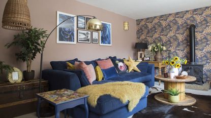 living room with wallpaper and blue sofa