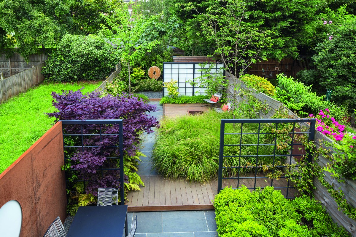 Garden screening zones off decking area surrounded by lush greenery