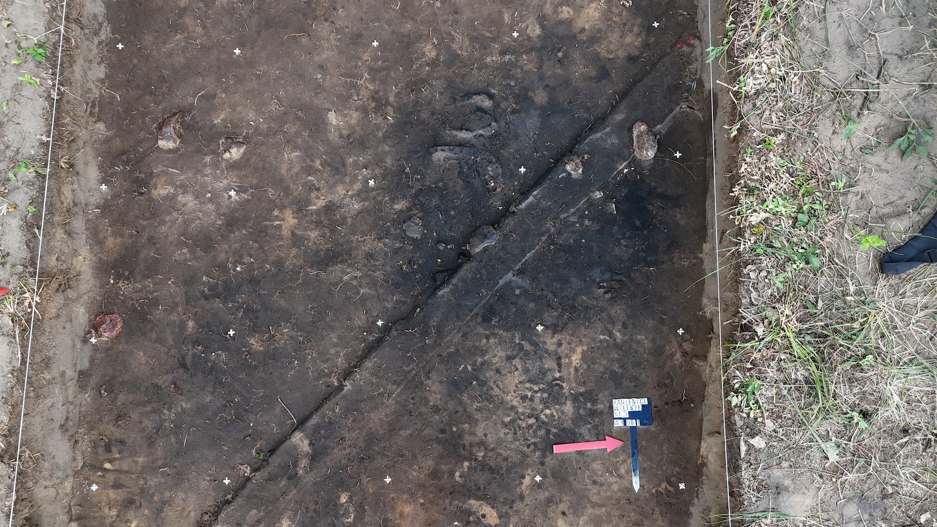 An aerial view of a rectangular excavation site filled with dirt