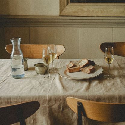 Wine glass and fresh bread on a dinner table