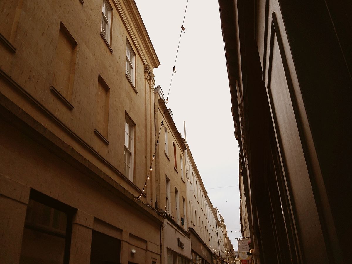 Sample image taken with Camp Snap 2 digital compact camera, showing upward view of narrow gap between buildings, with fairy lights strung across