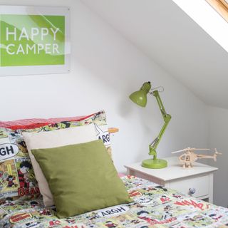 kids bedroom with green themed bed linen and lamp on bedside table