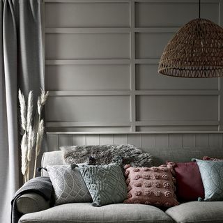 bedroom with grey sofa and woven pendant ceiling shade