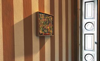 Framed painting on striped wall