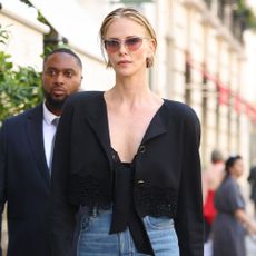 Charlize Theron wears wide-leg jeans with tall clog heels and a black shirt.