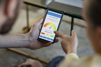 Two people looking at a credit report on a smartphone