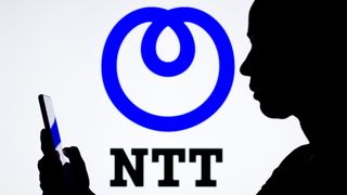 NTT logo displayed on a white background with person holding smartphone in foreground.