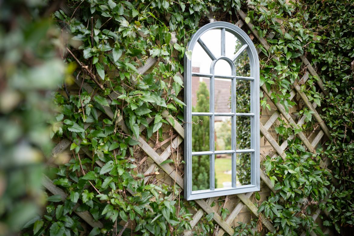 Ivy-covered trellis with a garden mirror.