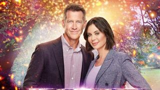 A man and woman stand in front of an enchanted sparkly background