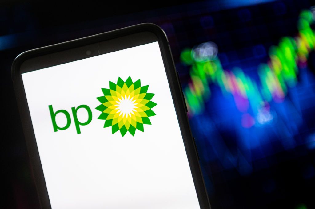 British Petroleum BP logo seen displayed on a smartphone with a share price chart in the background