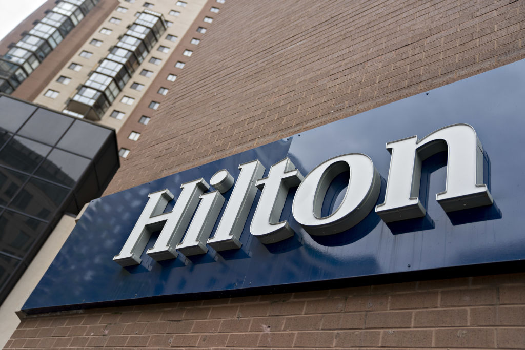 Signage is displayed outside the Hilton hotel in Arlington, Virginia, U.S., on Thursday, April 23, 2020. The largest U.S. hotel and lodging chains including Hilton Worldwide Holdings Inc. have raised more than $21 billion in loans since March 9 to help weather the coronavirus storm. Photographer: Andrew Harrer/Bloomberg