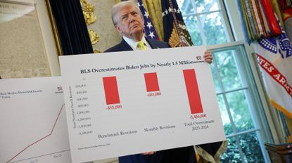 WASHINGTON, DC - AUGUST 07: U.S. President Donald Trump holds a poster which reads "Bureau of Labor Statistics (BLS) Overestimates Biden Jobs by Nearly 1.5 Million" in the Oval Office on August 07, 2025 in Washington, DC. Trump fired Bureau of Labor Statistics Commissioner Dr. Erika McEntarfer on August 1st, claiming the agency issued “phony” jobs numbers during the Biden administration to aid Democrats.