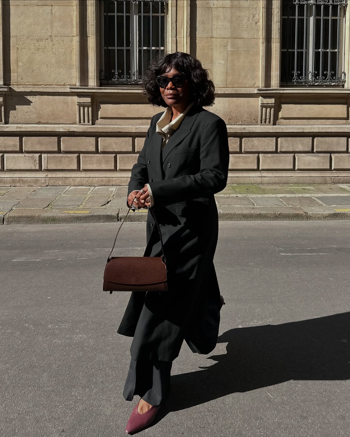 Influencer Franny wears a long coat with a burgundy East West bag.
