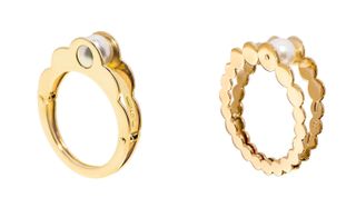 Two shell-shaped rings joined at the bottom and separated at the top by a singular oyster pearl sitting between the two rings.