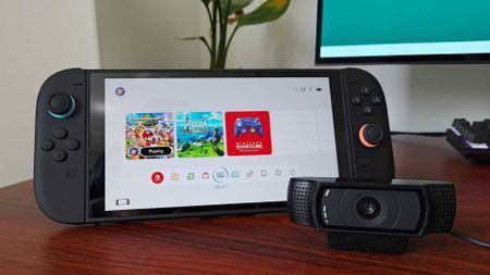 Nintendo Switch 2 on desk next to Logitech C920 webcam.