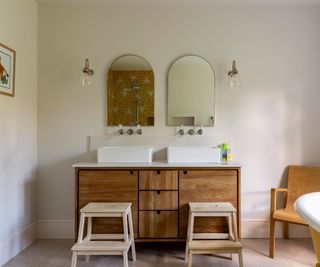 Freestanding wooden bathroom vanity in a white bathroom