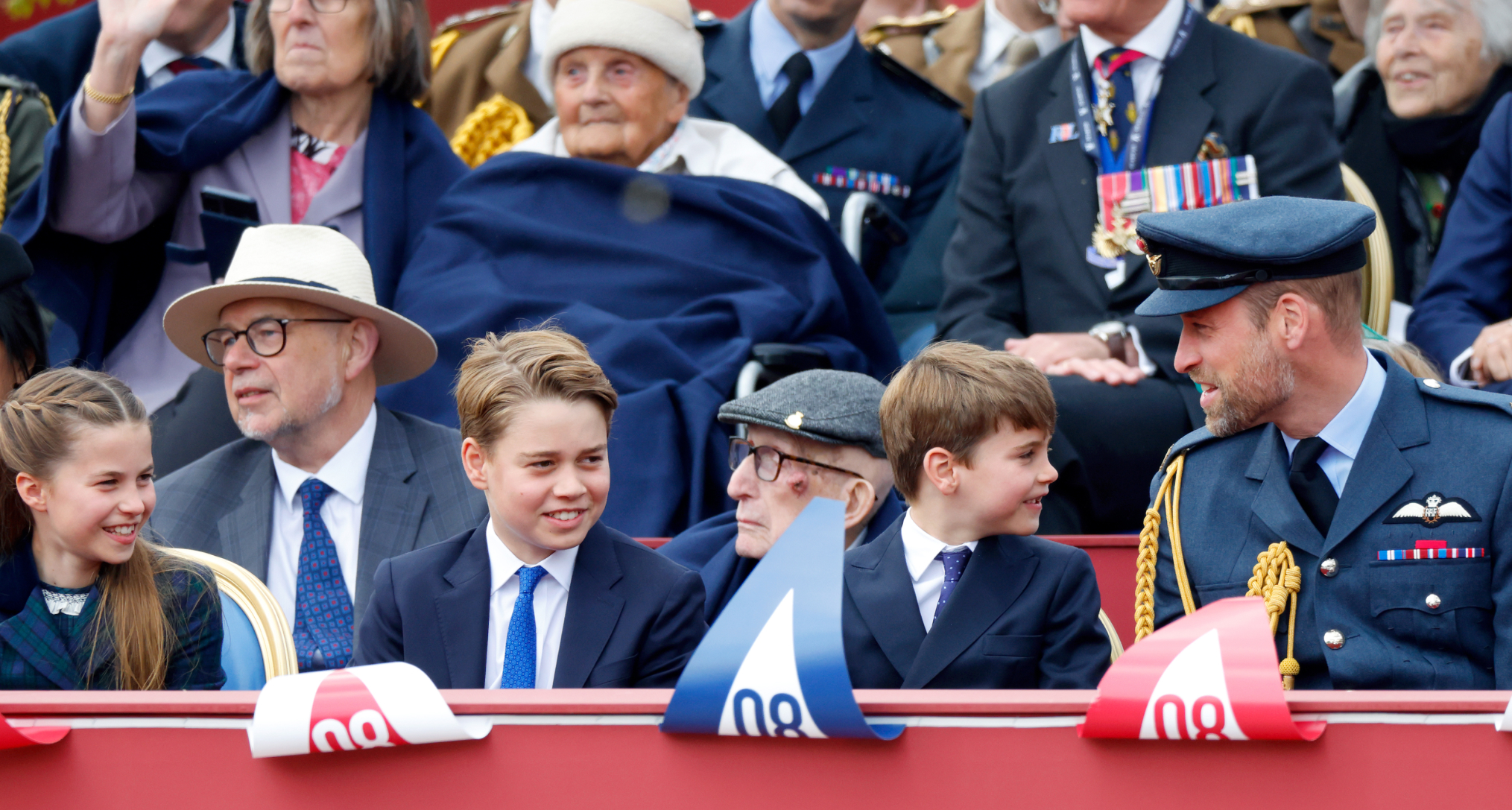 Princess Charlotte, Prince George, Prince Louis and Prince William sitting in a row on VE Day