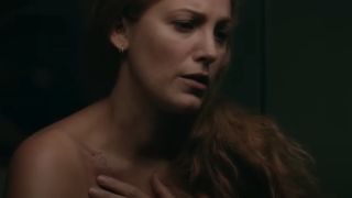 Blake Lively as Lily touching a heart tattoo on her collar bone that has bite marks around it.