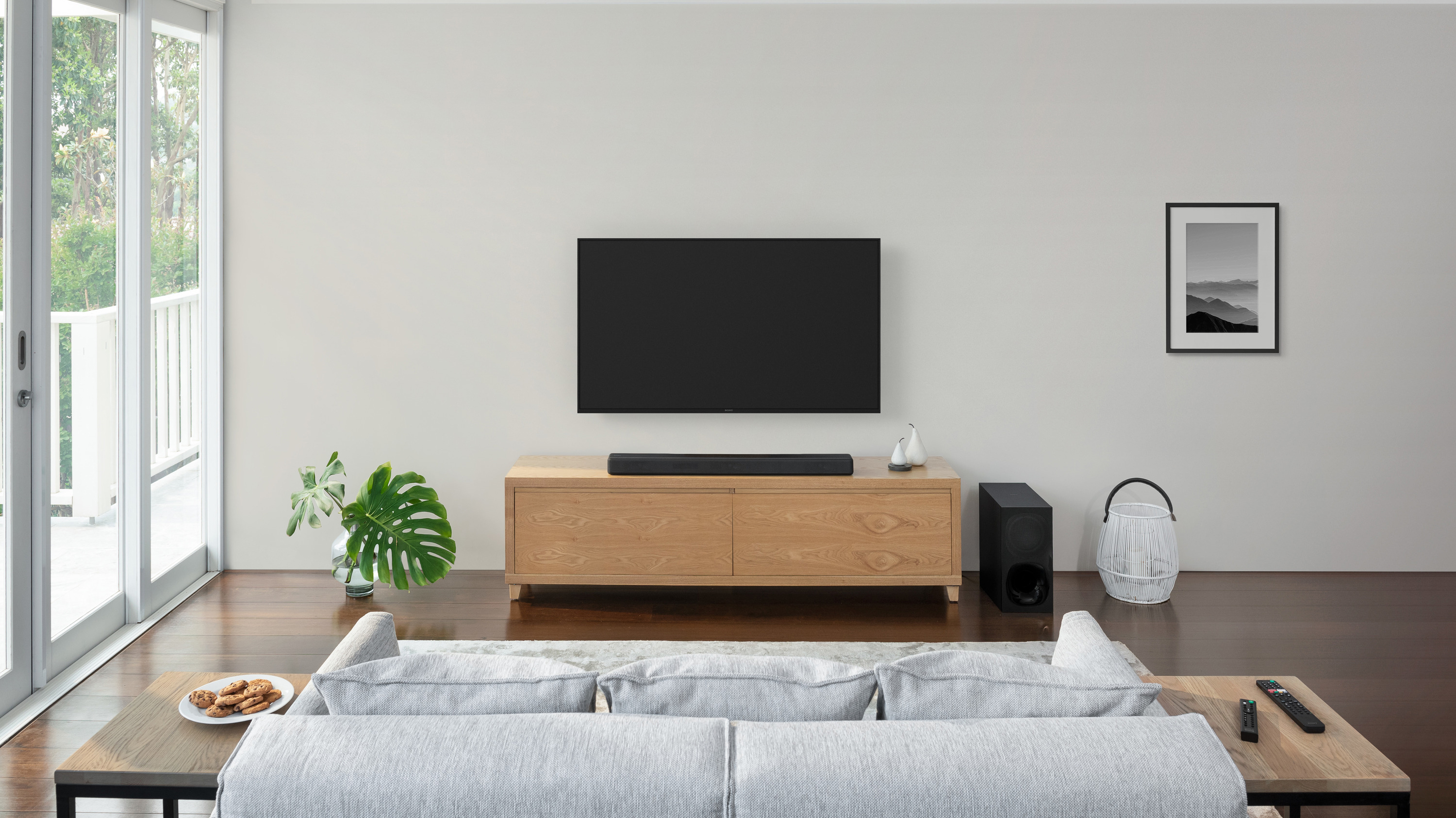 Die Sony HT-G700 Soundbar, abgebildet im Wohnzimmer unter einem Fernseher auf einem Holzschrank