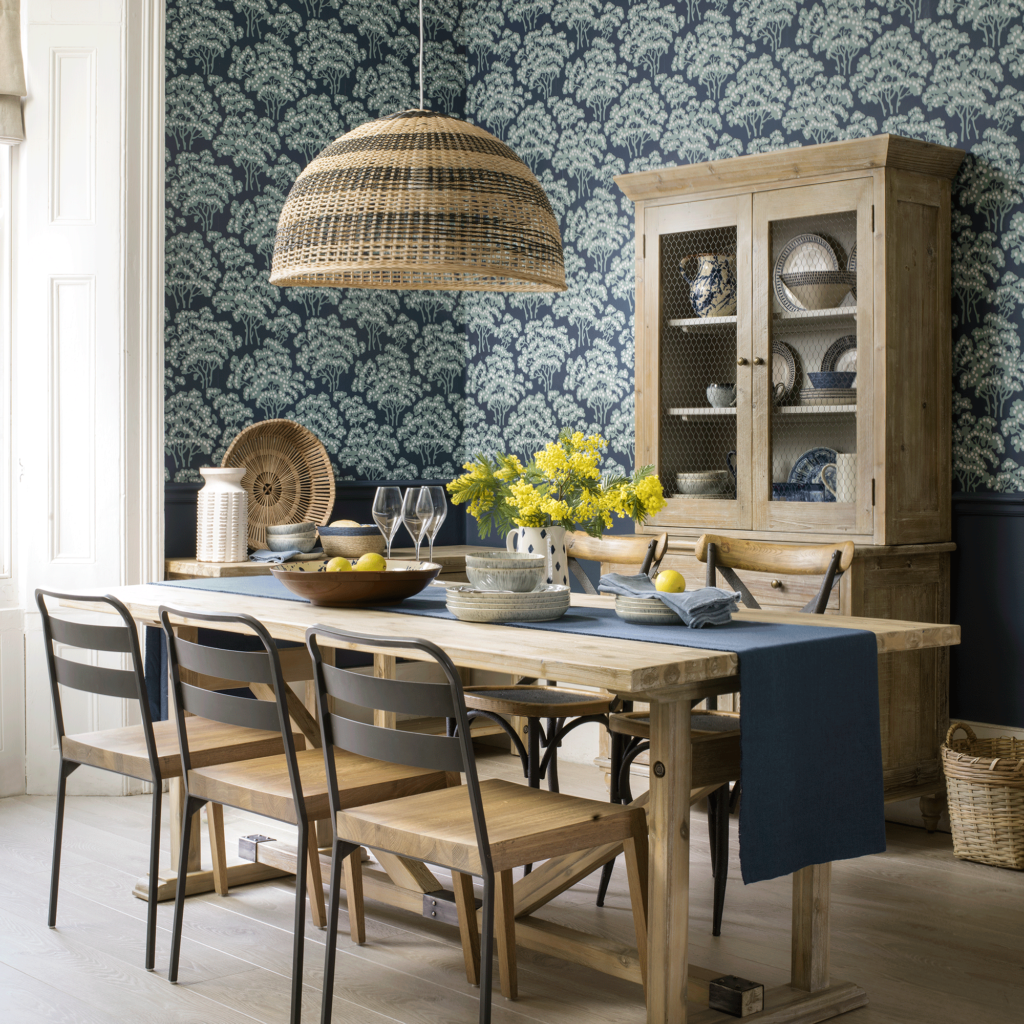 Blue wallpapered dining room with wooden table