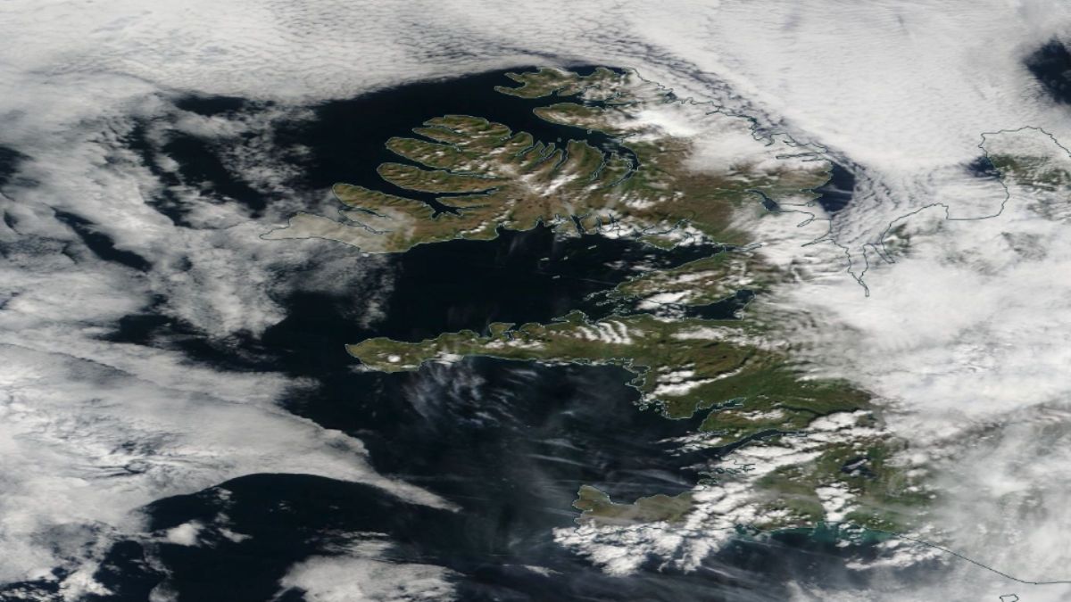 Satellite view of Iceland showing partly cloudy skies and deep blue water.
