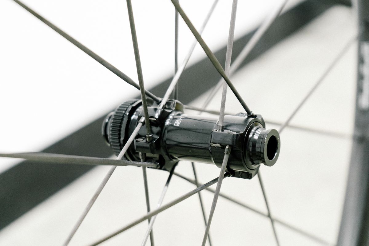 An aero road wheel stands against a white wall