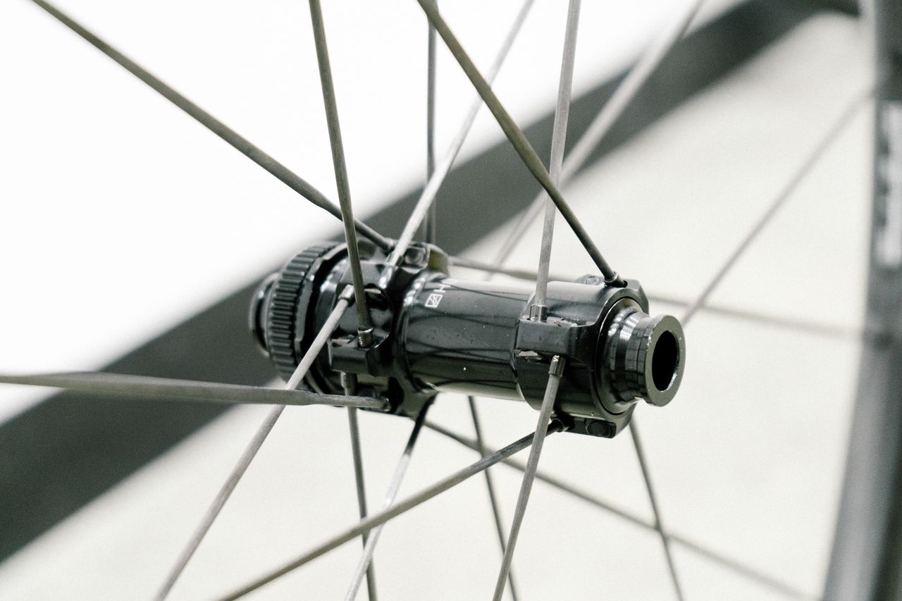 An aero road wheel stands against a white wall