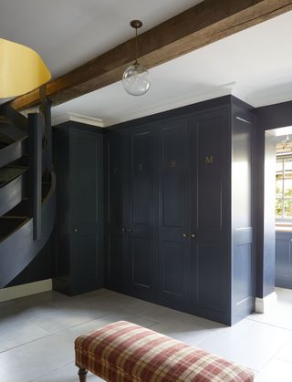 hallway with large cupboards in dark blue with initials on each door