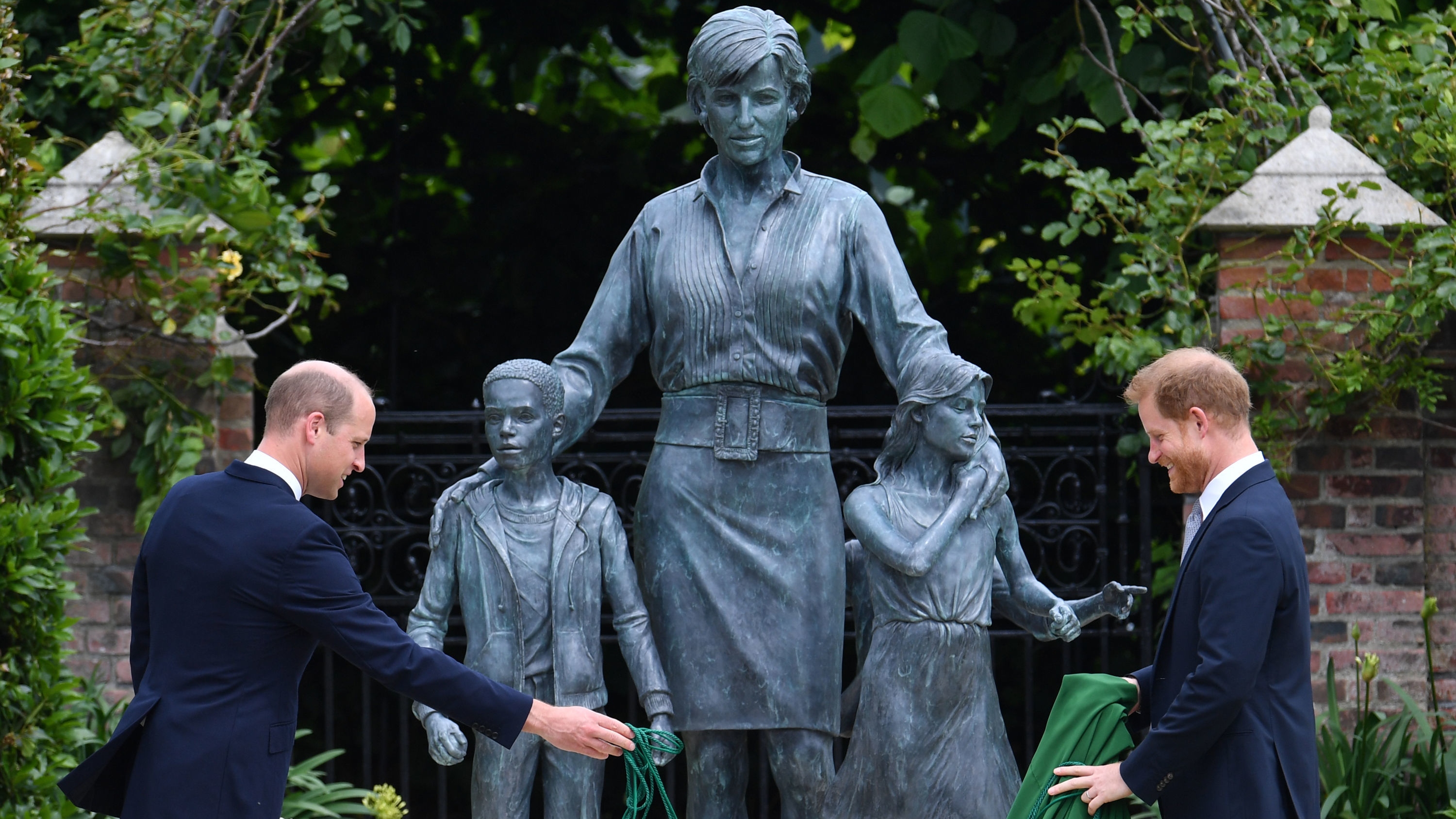 Prince William and Prince Harry unveil a statue they commissioned of their mother Diana, Princess of Wales, in the Sunken Garden at Kensington Palace