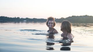 Two young women swimming in a lake