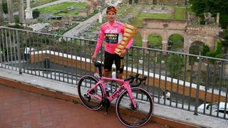 Primoz Roglic posing with pink giro winning bike