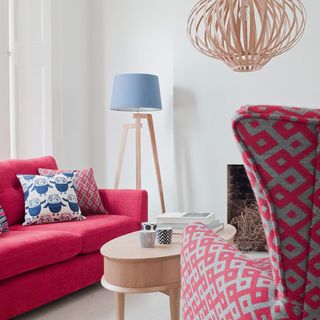 white living room with pink sofa with cushions